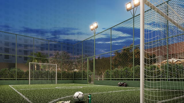 Campo de futebol society iluminado ao entardecer do Residencial Dona Ivone Lara, no Santo Cristo